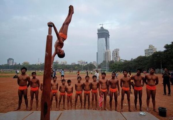 Мальчик демонстрирует индийскую гимнастику Маллахамб 