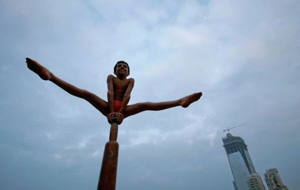 Мальчик демонстрирует индийскую гимнастику Маллахамб 