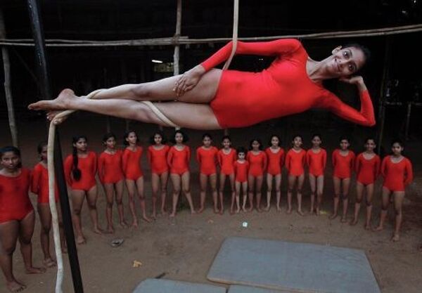 Девушка демонстрирует индийскую гимнастику Маллахамб 