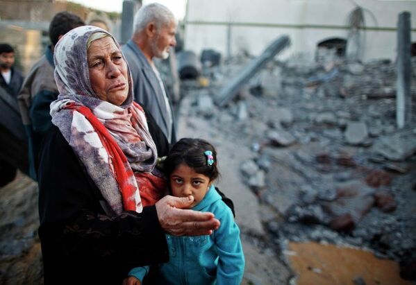 Жители Сектора Газа у разрушенного дома