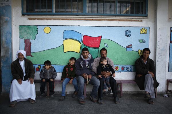 Палестинцы сидят у школы ООН в Секторе Газа