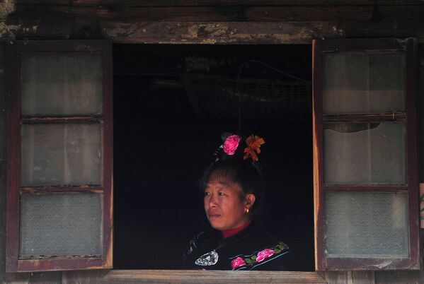 Представительница народности Мяо ждет гостей в первый день праздника «Гуцзан»