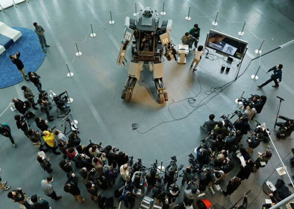 Представители СМИ у боевого робота «Kuratas» на выставке в Токио, Япония