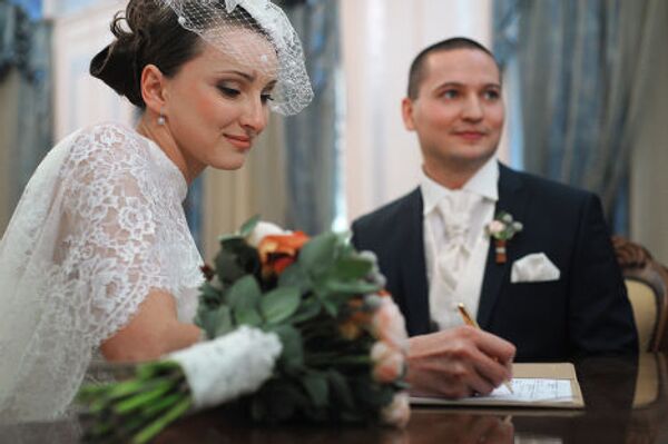 Молодожены оформляют документы во время церемонии бракосочетания во Дворце бракосочетаний №3 в Москве