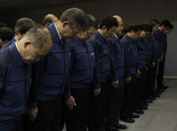 Сотрудники Tokyo Electric Power Co (TEPCO) во время минуты молчания в память жертв землетрясения и цунами 2011 г.