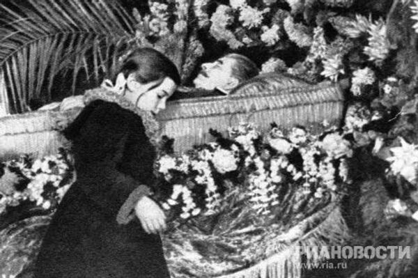Девочка возлагает цветы к гробу с телом Сталина