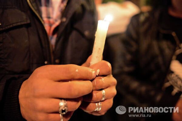Участница шествия сторонников лидера оппозиционной партии Наследие держит в руках свечу