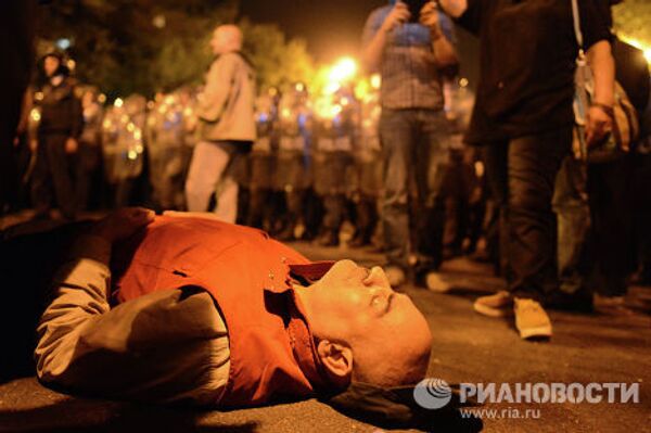 Участник шествия лежит на асфальте в знак протеста против результатов президентских выборов