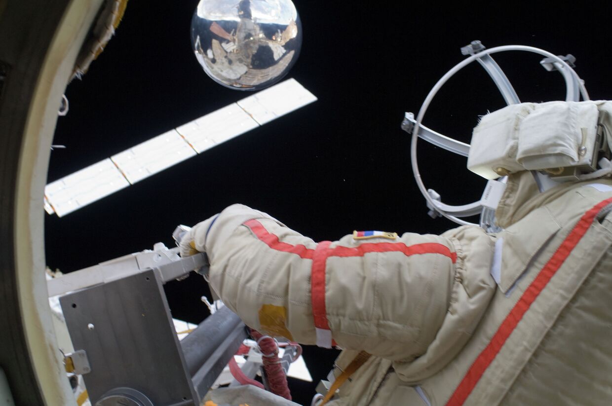 Космонавт Геннадий Падалка запускает микроспутник Сфера во время выхода в открытый космос