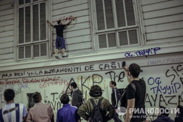 Один из протестующих на стене здания во время столкновения с сотрудниками полиции в Стамбуле