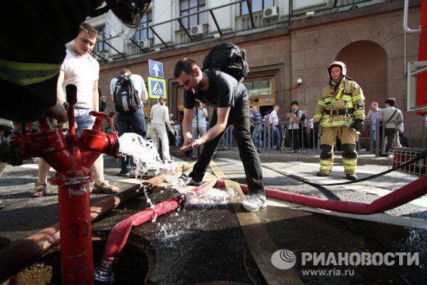 Пассажиры отмываются от копоти у станции метро Охотный ряд в центре Москвы, которую закрыли из-за пожара.