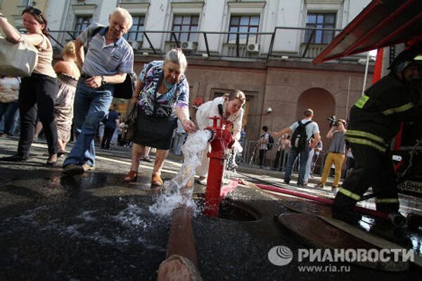 Пассажиры отмываются от копоти у станции метро Охотный ряд в центре Москвы, которую закрыли из-за пожара.