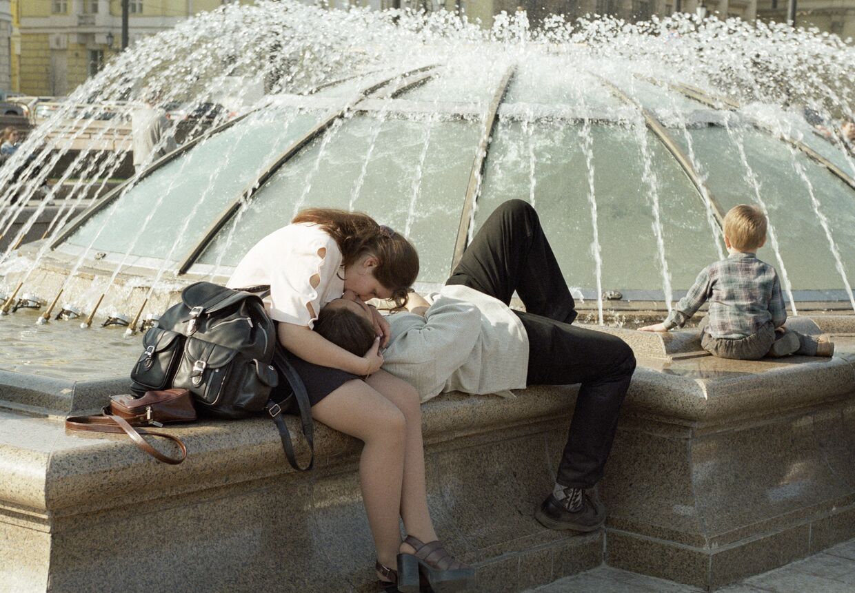 Влюбленные целуются возле фонтана на Манежной площади