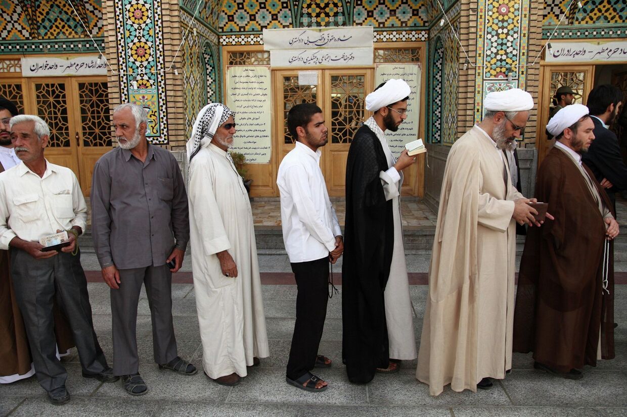 Мужчины стоят в очереди в мечети в Куме, чтобы проголосовать во время иранских президентских выборов