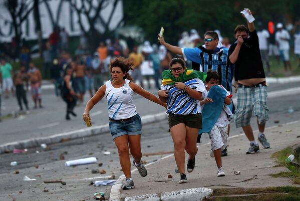 Футбольные болельщики бегут в укрытие во время беспорядков в Бразилии