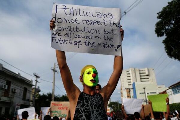 Демонстрант с плакатом во время протеста в Ресифи, Бразилия