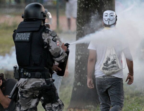 Полицейский применяет слезоточивый газ против демонстранта в Сальвадоре