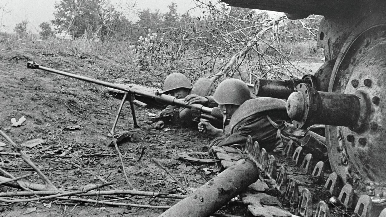 Гвардейцы-бронебойщики отражают танковую атаку врага, лежа рядом с подбитым танком. Курская дуга