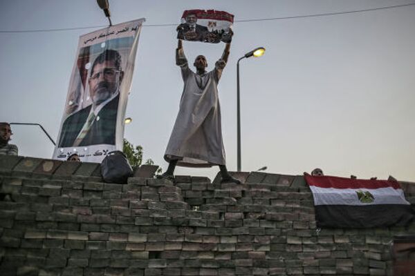 Сторонники свергнутого президента М.Мурси у стены, которой они обнесли палаточный лагерь у мечети Рабиа Аддавия в Каире