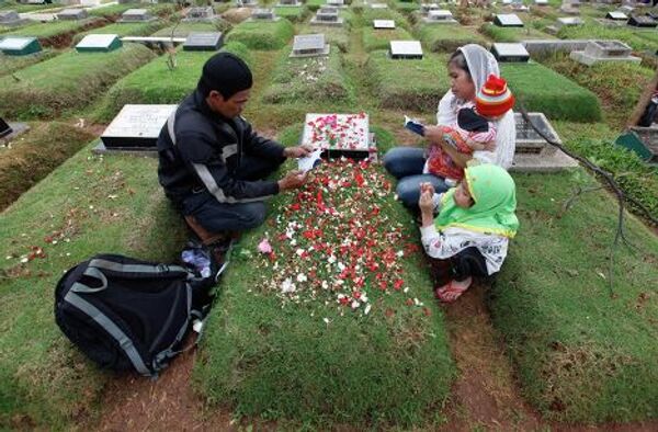 Жители Индонезии посещают кладбище накануне священного месяца Рамадан