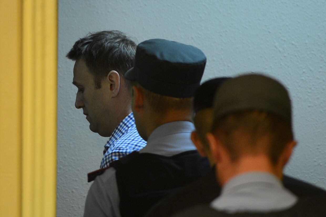 Сотрудники полиции уводят из зала суда Алексея Навального