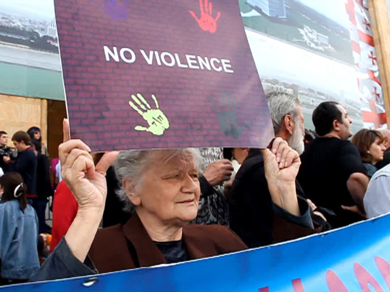 Женщина с плакатом «Нет насилию»