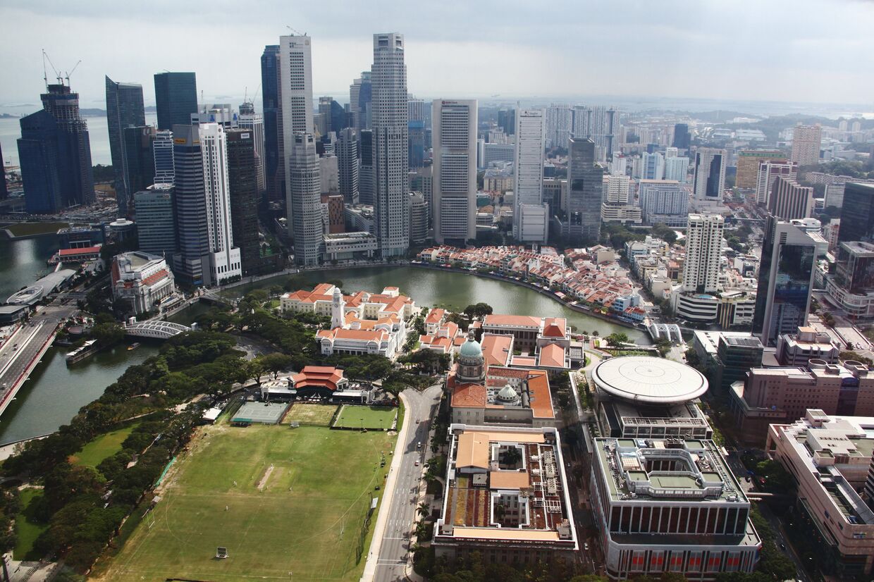 Вид на башни «Сити» за рекой и здания старого и нового парламента в Сингапуре