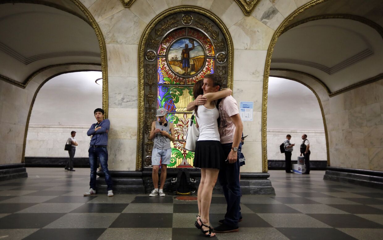 Пара на фоне витража на станции «Новослободская» московского метро