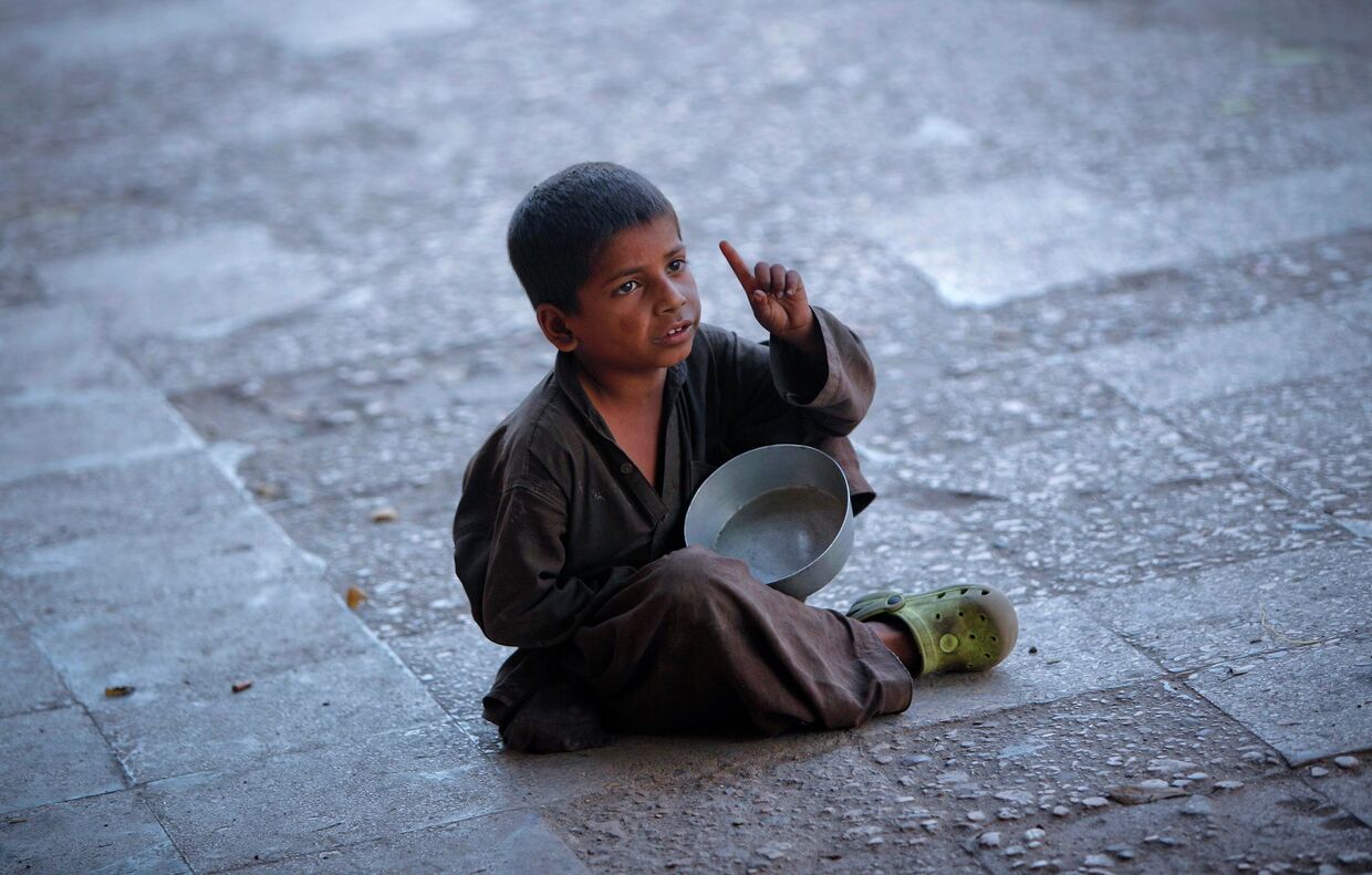Мальчик просит милостыню на одной из улиц Карачи