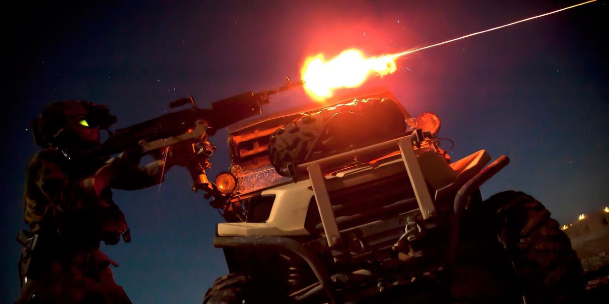 Морпех из команды спецопераций стреляет из пулемета M240B во время ночной тренировки в Афганистане