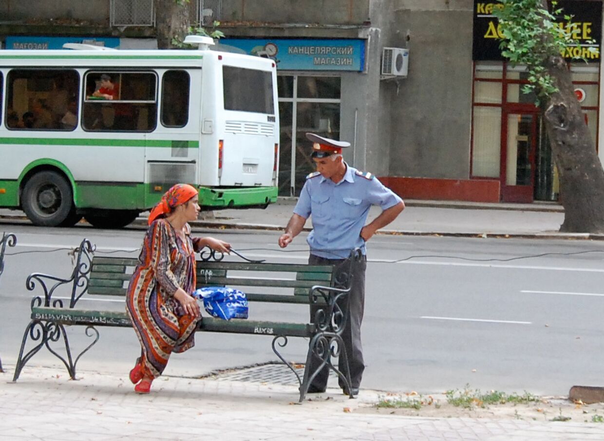 Милиционер разговаривет с женщиной на одной из улиц Душанбе
