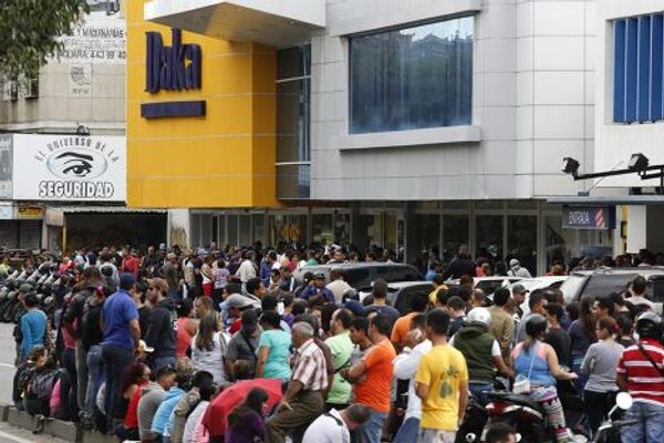 Покупатели рядом с торговым центром Daka в Каракасе