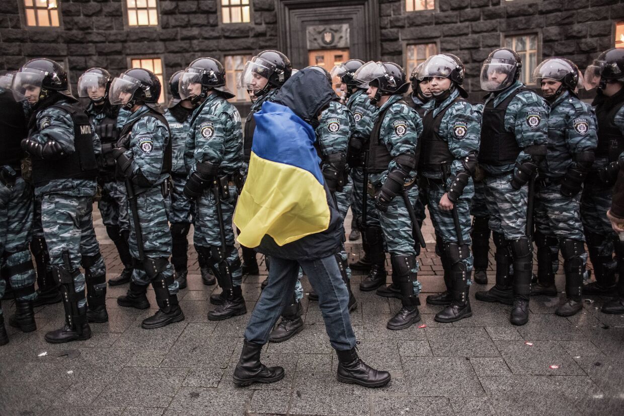 Сторонник евроинтеграции Украины и сотрудники милиции у здания правительства страны в Киеве