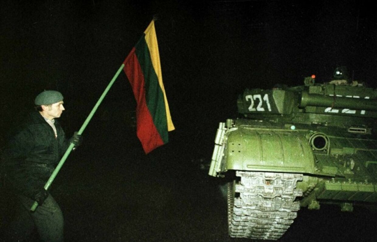 Один из протестующих с флагом около советского танка. Ночь 13 января 1991 года