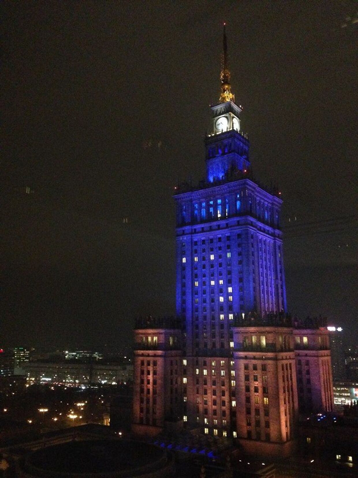 Дворец культуры и науки осветили синим и желтым в знак поддержки украинцам