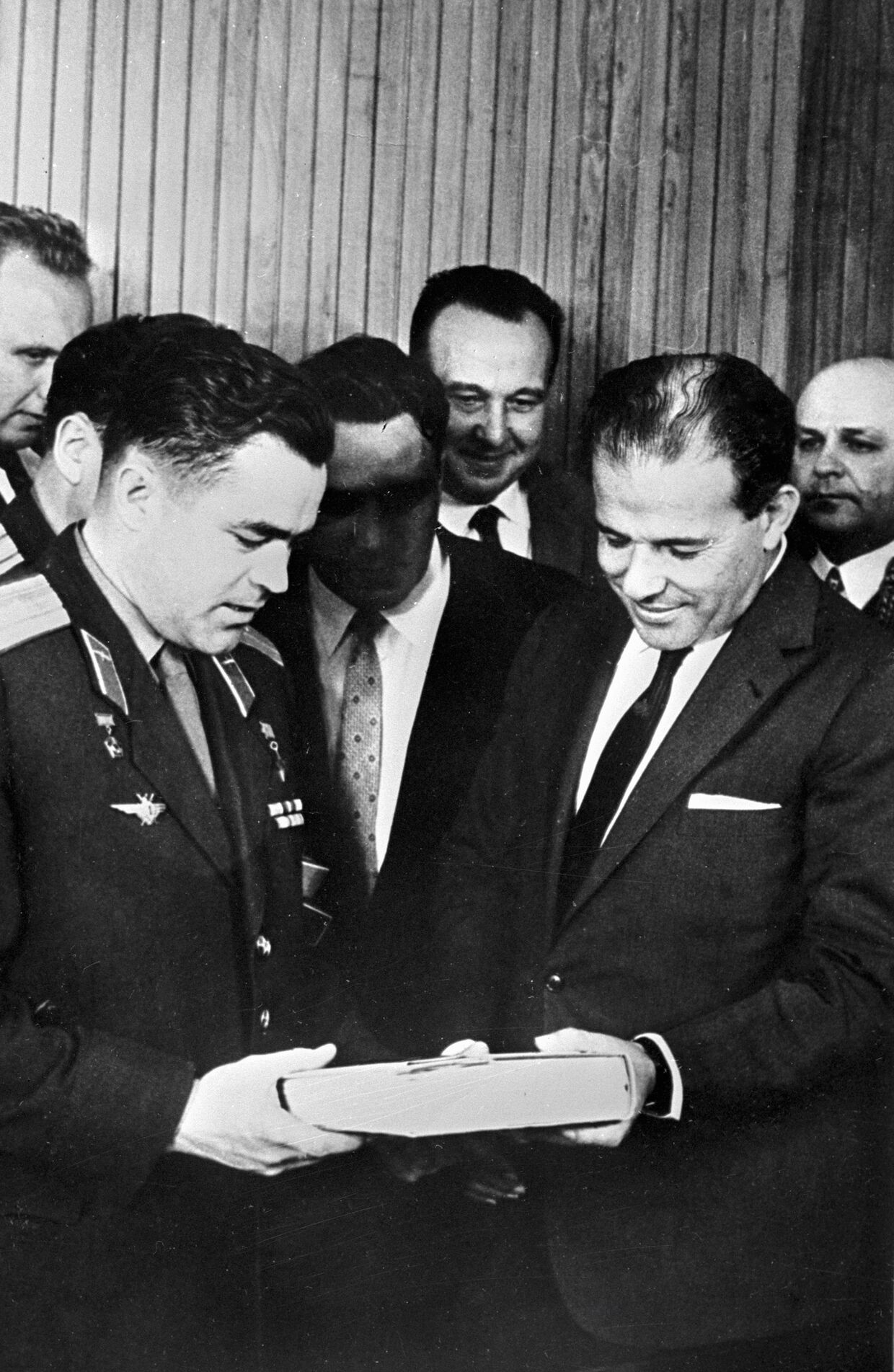 Президент Бразилии Жоао Гуларт (справа) принимает от летчика-космонавта Андрияна Николаева (слева) книгу о космическом полете.