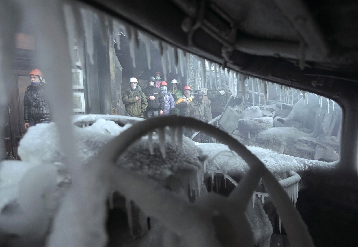 Сгоревшая машина на месте столкновений протестующих с полицией в Киеве