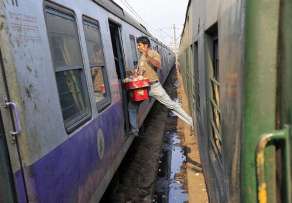 Торговец делает пересадку на железнодорожной станции в Калькутте, Индия