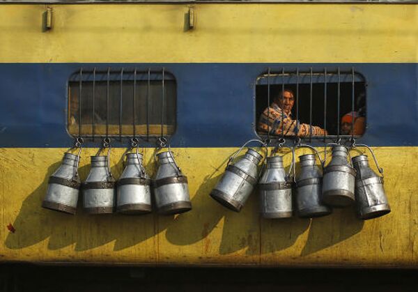 Поезд с закрепленными на нем бидонами для молока на окраине Нью-Дели, Индия