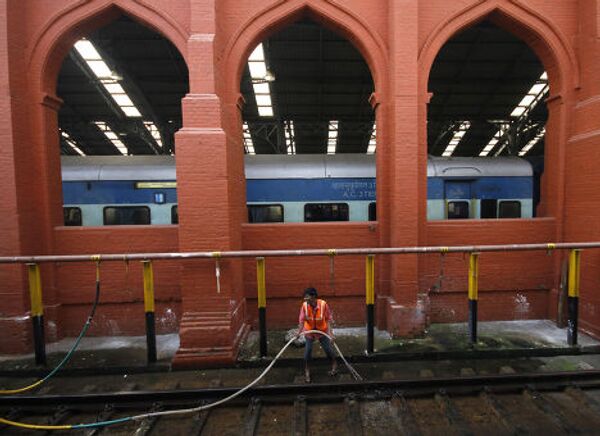 Рабочий моет пути на станции в Ченнаи, Индия