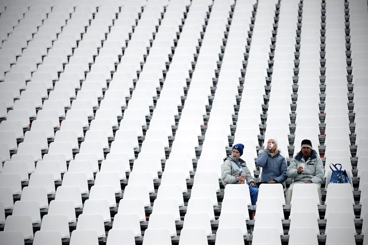 Зрители на трибуне стадиона после объявления об отмене по погодным условиям финала сноуборд-кросса на соревнованиях по сноуборду среди мужчин