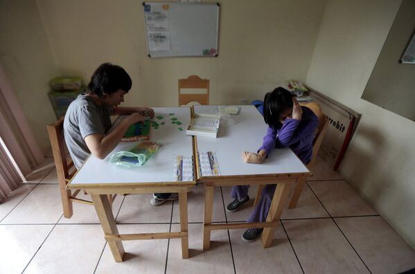 Мальчик собирает паззл в Терапевтическом и развивающем центре для детей, больных аутизмом, в Гватемале