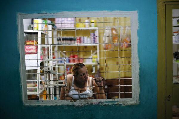 Женщина выглядывает из окна своего магазина в коридоре небоскреба «Башня Давида» в Каракасе