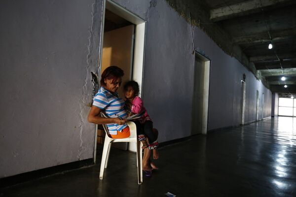 Женщина с внучкой разгадывают кроссворд в коридоре небоскреба «Башня Давида» в Каракасе