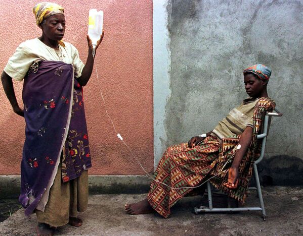 Женщина хуту помогает дочери делать нутривенную инъекцию в больнице города Гомы