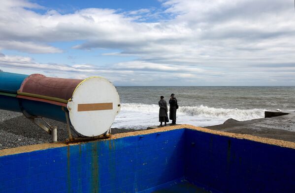Люди стоят на берегу Черного моря в Алуште