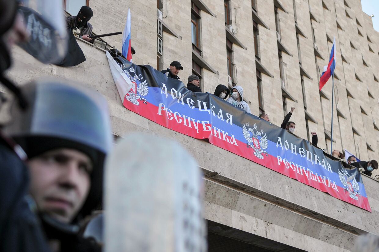 Участники митинга в Донецке, организованного сторонниками референдума о статусе региона, на здании областной администрации