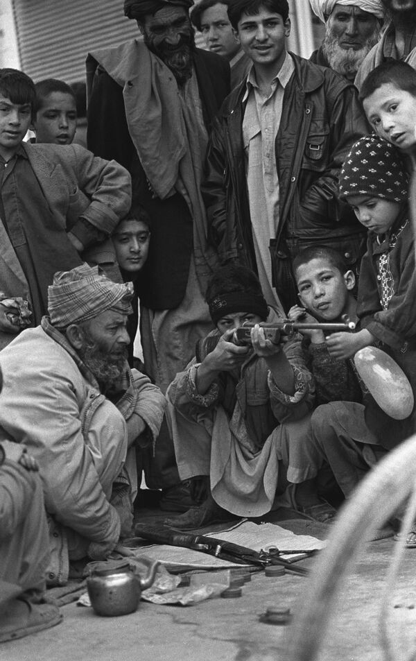 Мальчик учится стрелять из ружья. Фотография Захры Каземи