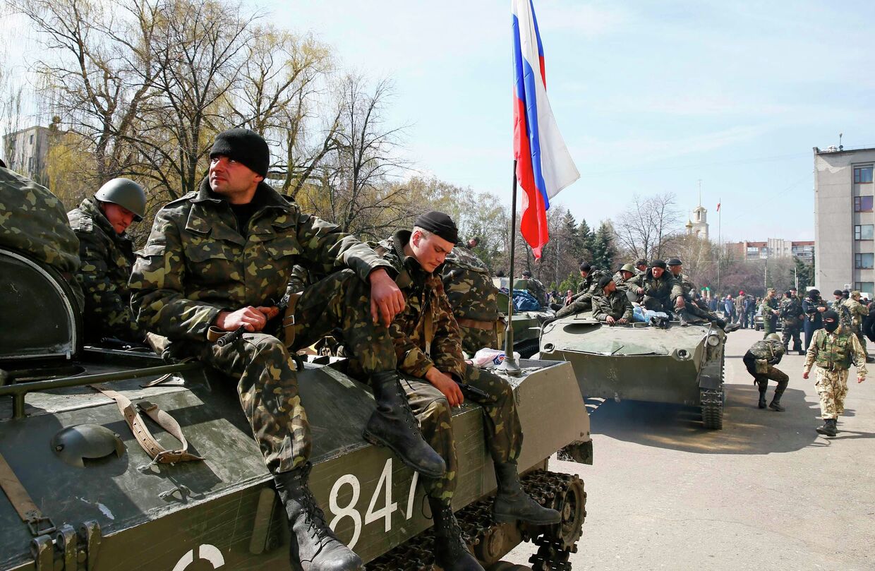 Люди в военной форме на боевой технике с флагом России в Славянске. 16 апреля 2014