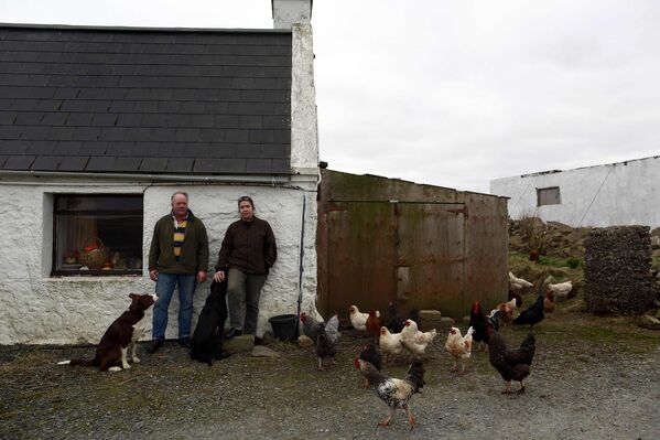 Жители деревни Сэнднесс на острове Мейнленд у своего дома
